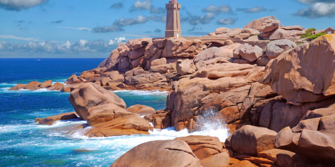 a lighthouse on a rocky beach